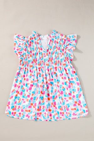 Smocked bodice blouse with brushstroke print, V-neck, and flutter sleeves in a multi-color pastel palette.