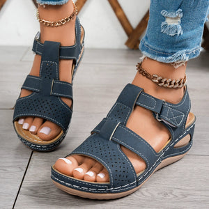 Blue perforated mid-wedge sandals with adjustable straps and white stitching.