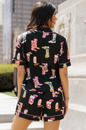 Black silk pajama set with a colorful cowboy boot print and pink piping.