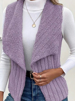 Lilac textured teddy collarless vest with shawl collar, styled with a white turtleneck and jeans.