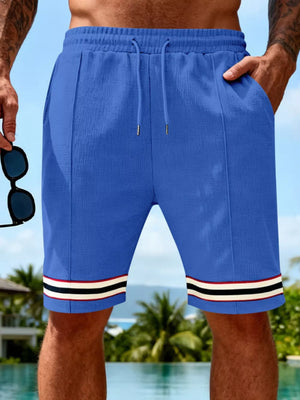 Blue textured knit drawstring shorts with pockets and striped cuffs.