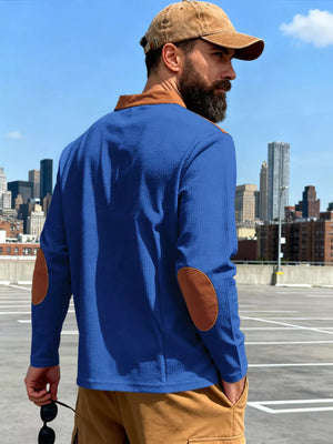 Blue long-sleeve men's t-shirt with brown elbow patches and collar detail.