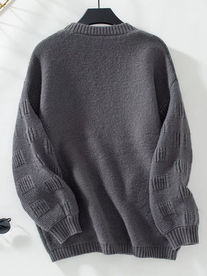 Dark gray chunky knit cardigan with textured sleeves and ribbed cuffs.