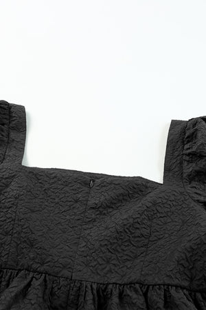 Black peplum blouse with square neckline and textured fabric.
