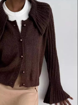 Chocolate acrylic cardigan with oversized ribbed collar and pearl buttons, flared sleeves.