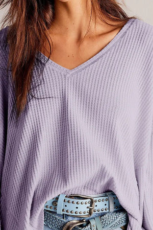 Lavender waffle knit v-neck top with blouson sleeves, styled with a studded belt.