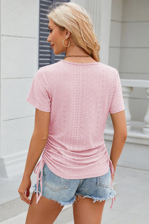 Blush pink perforated tee with short sleeves and gathered sides with drawstring ties.