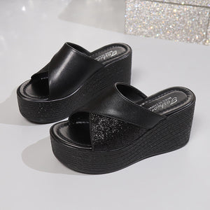 Black open-toe wedge sandals with glitter detail and cross-over straps.