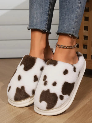 Cow print faux fur house slides in white and brown, with a thick sole.