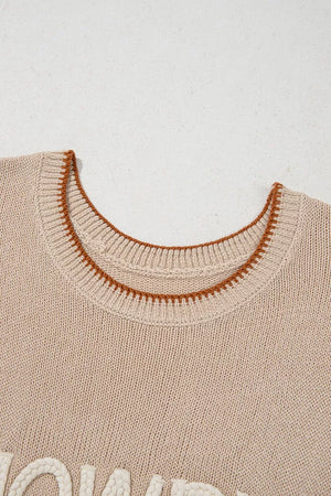 Beige knit sweater vest with contrast trim and textured lettering detail.