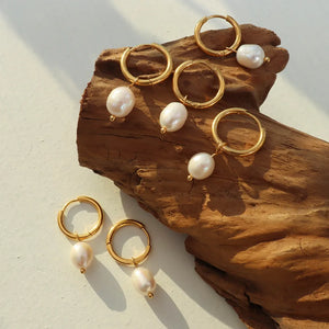 Gold hoop earrings with lustrous pearl drops, chic and elegant for women.