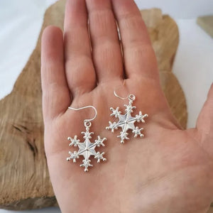 Silver snowflake drop earrings with delicate details.
