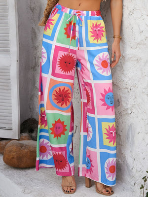 Geometric print wide-leg trousers with drawstring waist in multicolor sun pattern.