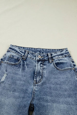 Cuffed mid-rise relaxed fit jeans in distressed blue denim with pocket details.