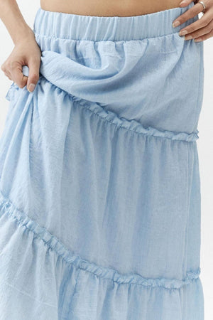 Tiered cotton maxi skirt in light blue with ruffled tiers and an elastic waistband.