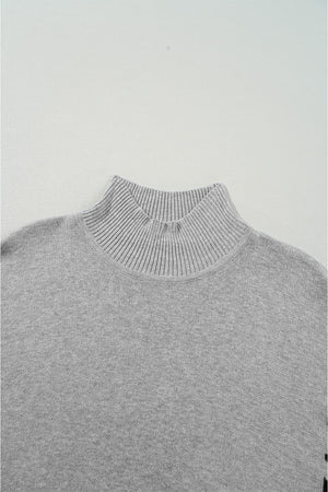 Gray acrylic knit sweater with mock neck and asymmetric leopard panel detail.