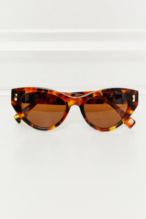 Cat-eye sunglasses in tortoise shell acetate with brown lenses and gold accents.