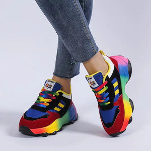 Rainbow gradient chunky sneakers with red and mustard accents, featuring colorful laces.