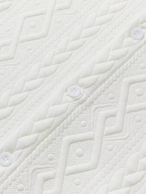 Off-white knit polo with textured geometric pattern and white buttons.