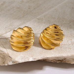 Sculpted spiral gold stud earrings with a textured, wavy design.