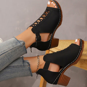 Black criss-cross cut-out block heel sandals with ankle strap and buckle detail.