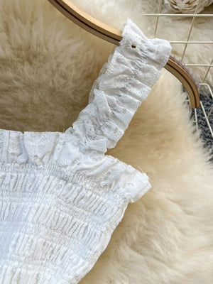 White eyelet ruffled crop top with smocked bodice detail.