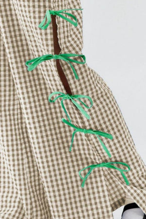 Gingham wide-leg trousers in tan with green bow details on the side seam.