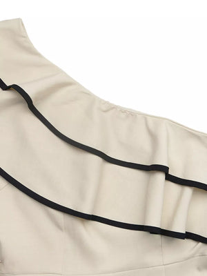 Cream one-shoulder romper with black trim and ruffle detail