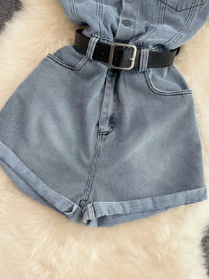 Light wash denim romper with black belt, button front, and cuffed shorts.