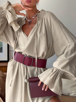 Beige cotton tie neck ruffled maxi dress with bell sleeves and a wide burgundy belt.