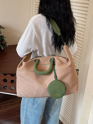Two-tone nylon duffle bag in camel and green with detachable pouch and strap.
