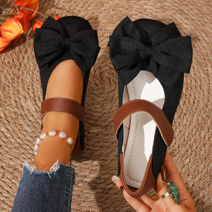 Black textured round toe flats with bow detail and brown strap.