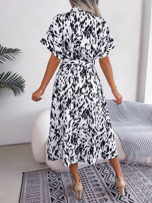 Dalmatian print midi shirt dress in white with black spots, short sleeves, and tie waist.