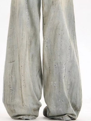 Light vintage wash wide-leg denim trousers with distressed details and paint splatters.