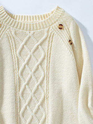 Cream cable knit raglan sweater with button shoulder detail.