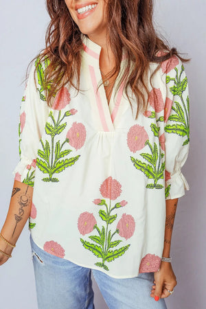 Cream cotton blouse with pink floral print, ruffled sleeves, and notched neckline.