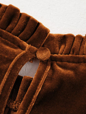 Brown velvet mock neck blouse with ruffled trim and button detail