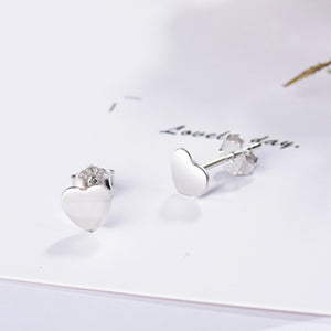 Elegant heart-shaped sterling silver stud earrings with butterfly backs.