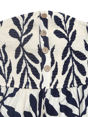 Chic smocked tube romper in ivory with navy leaf print and wooden button detail.