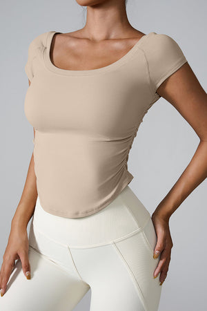 Sand performance tee with gathered side detail and scoop neck.