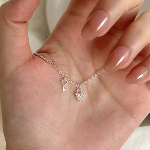 Sterling silver necklace with heart lock and key charms, one heart charm is crystal encrusted.