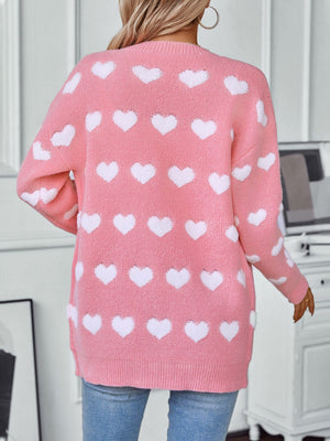 Blush pink jacquard knit cardigan with allover white hearts, acrylic, crew neck, long sleeves.