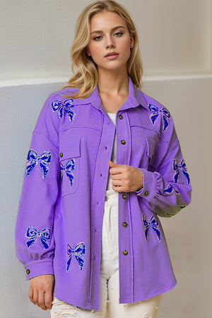 Purple oversized shacket with embroidered blue bow details and frayed hem.