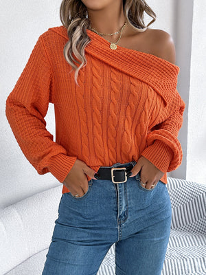 Orange off-shoulder cable knit pullover sweater with asymmetrical neckline and long sleeves.