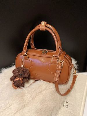Chic mini crossbody bag in chocolate PU leather with a cute dog charm and adjustable strap.