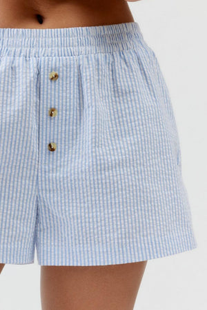 Light blue seersucker boxer shorts with button-down detail and elastic waistband.