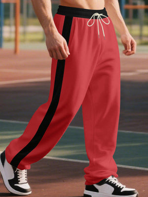 Men's bright red wide-leg sweatpants with black side stripe and drawstring.