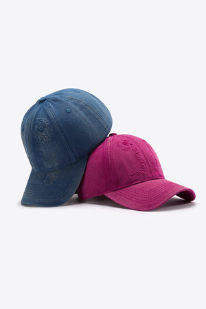 Two baseball caps, one navy denim and one cerise, with distressed embroidered details.