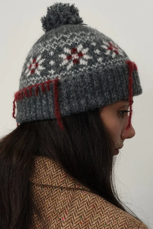 Dark gray Fair Isle beanie with pom-pom and red tassel detail