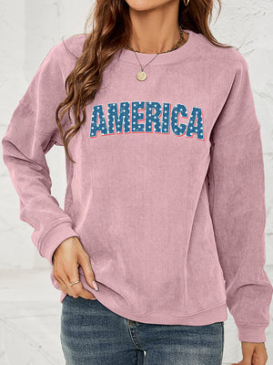 Dusty Pink corduroy sweatshirt with "AMERICA" graphic in star-spangled blue letters.